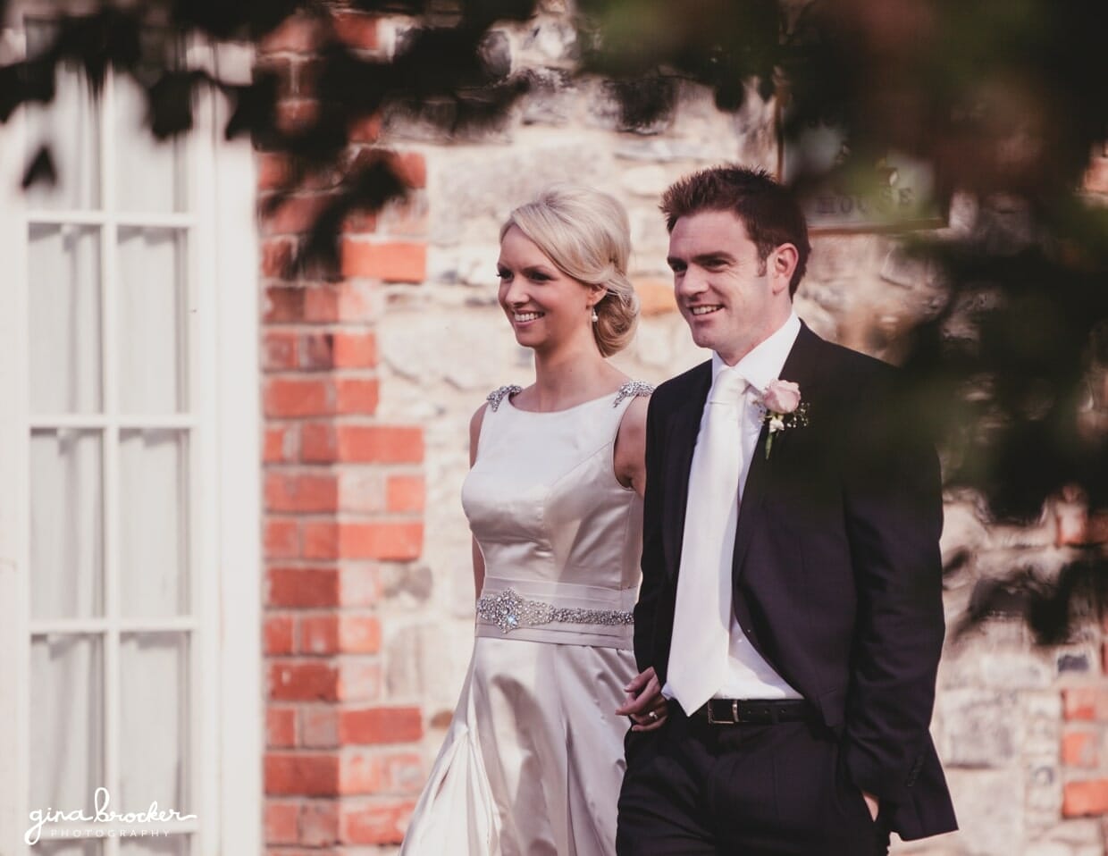 A candid photograph of a bride and groom walking to their wedding dinner during their classic garden wedding