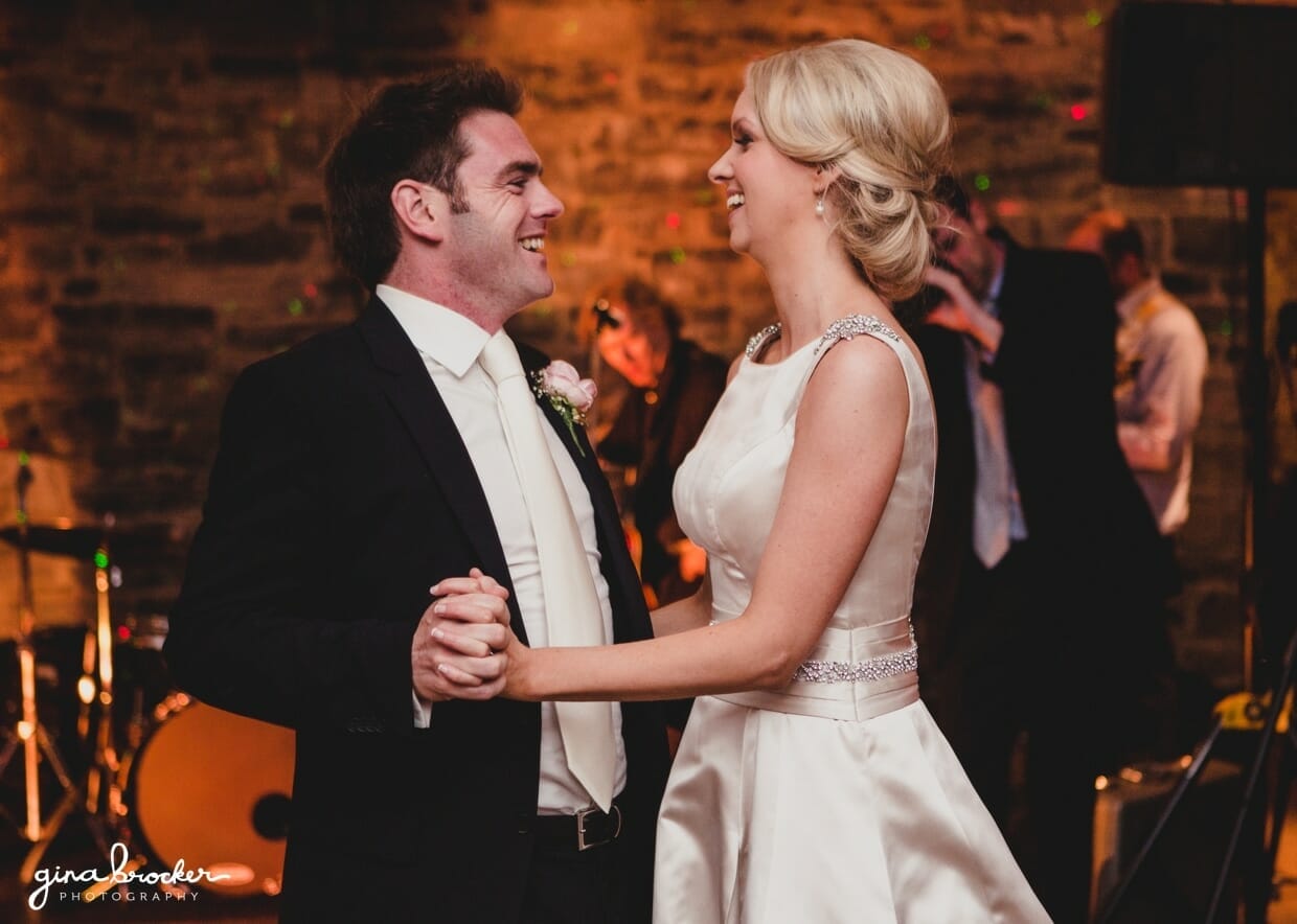 The bride and groom smile during their first dance as husband and wife