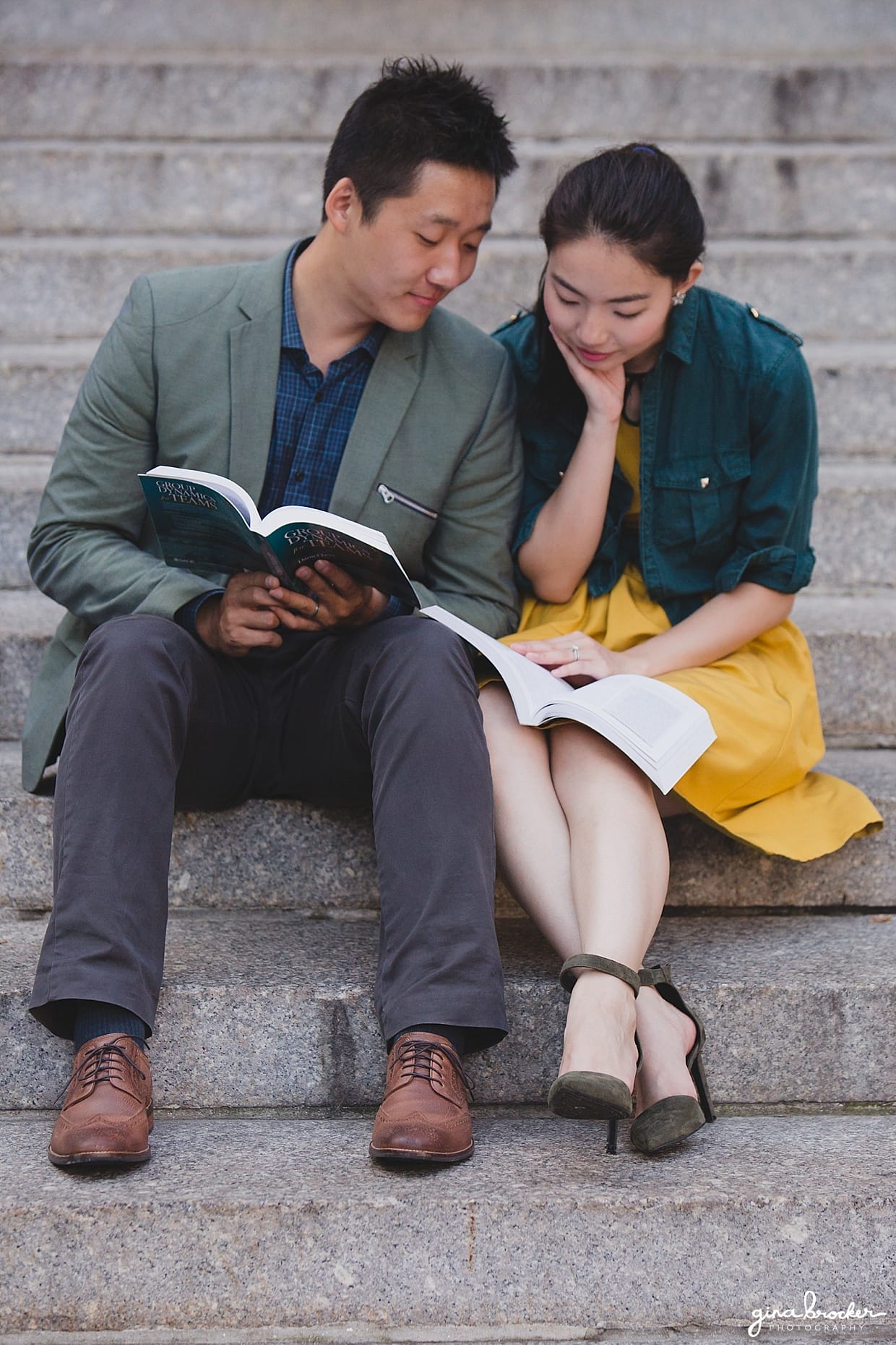 A couple sit together on the steps of Northeastern University and read books during their Boston Engagement Session