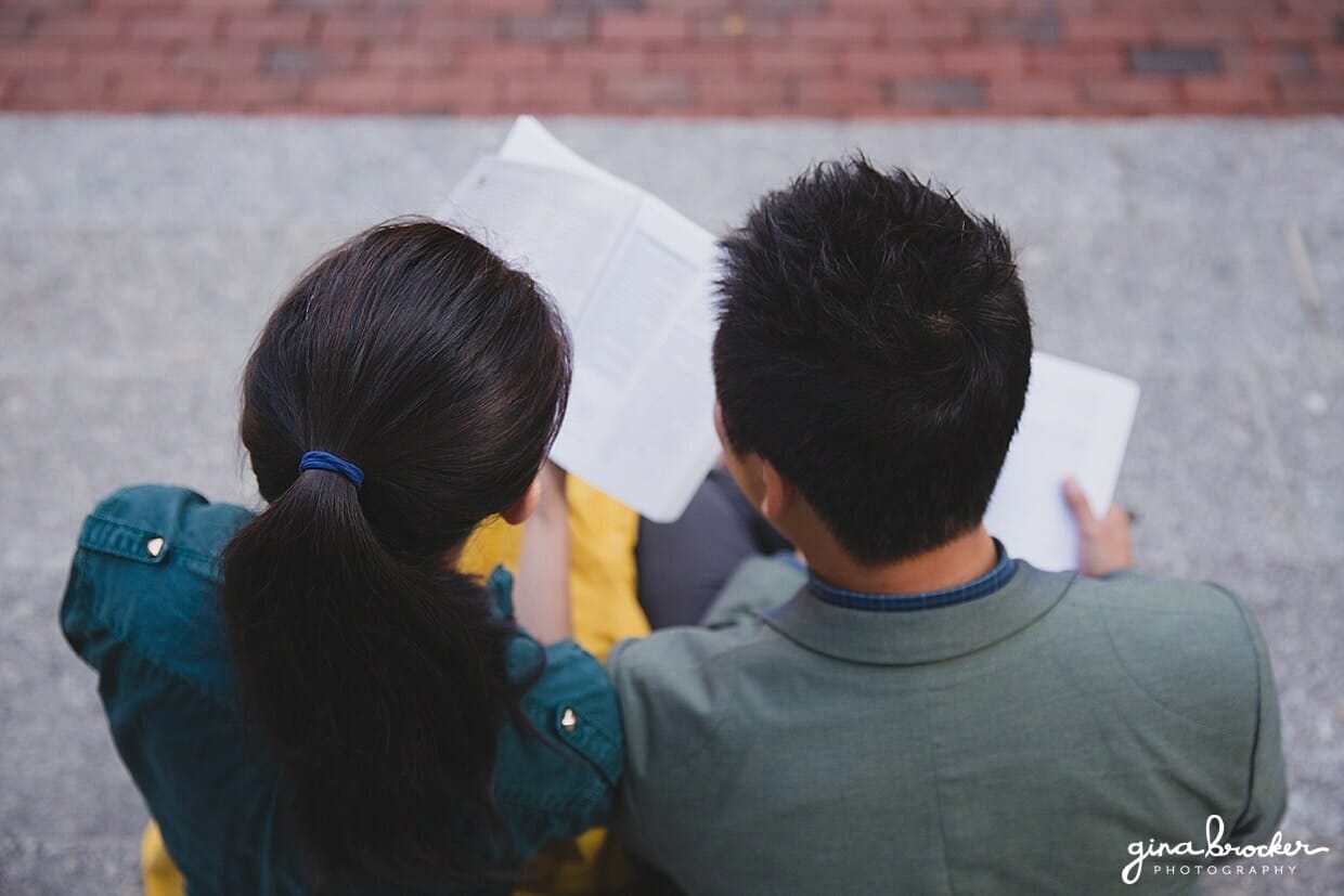An aerial photograph of a couple reading books on the steps of Northeastern University during their engagement session in Boston, Massachusetts