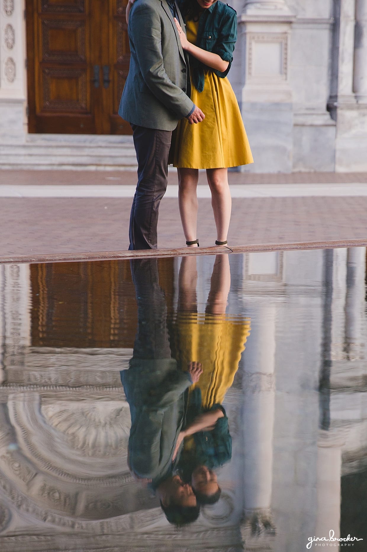 A couple look at their reflection in the reflecting pool at the Christian Science Center during their Boston Engagement Session