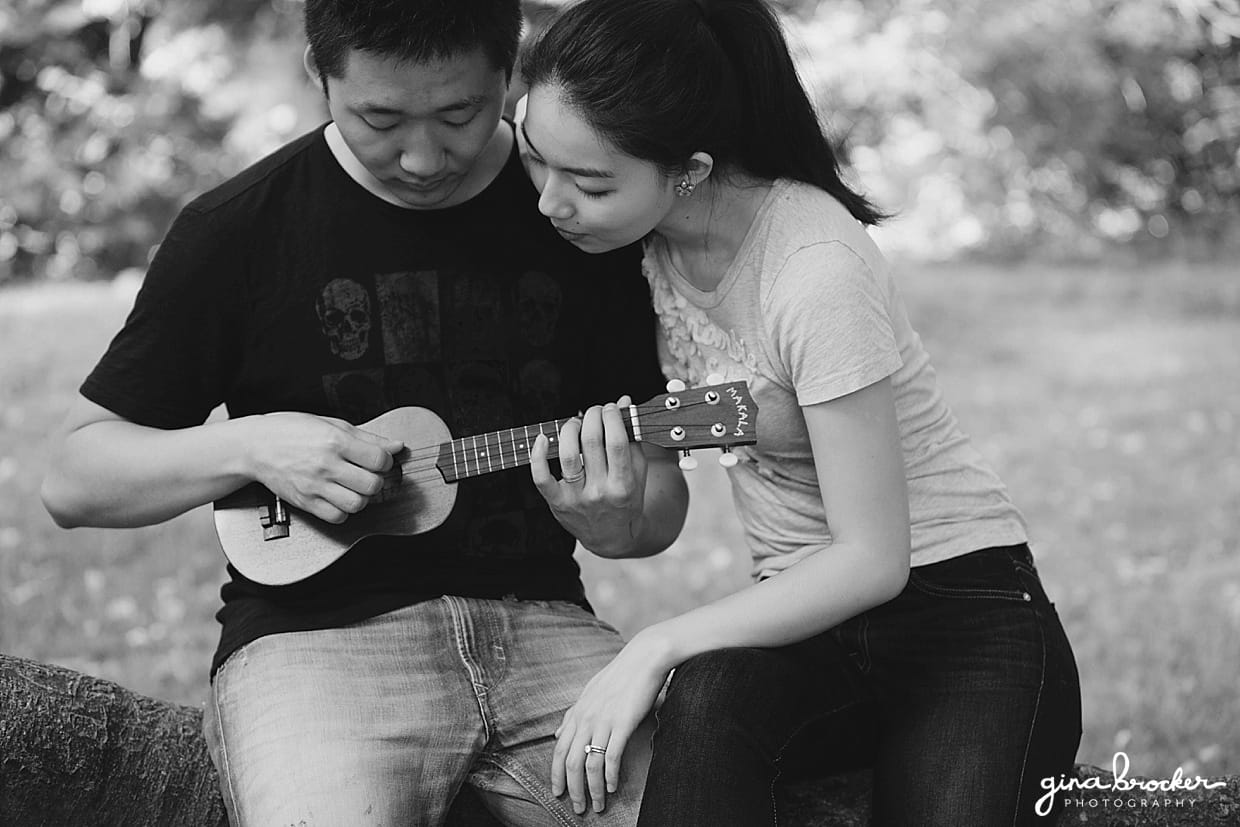 A couple cuddle while playing music during their park engagement session in Boston's Back Bay Fens