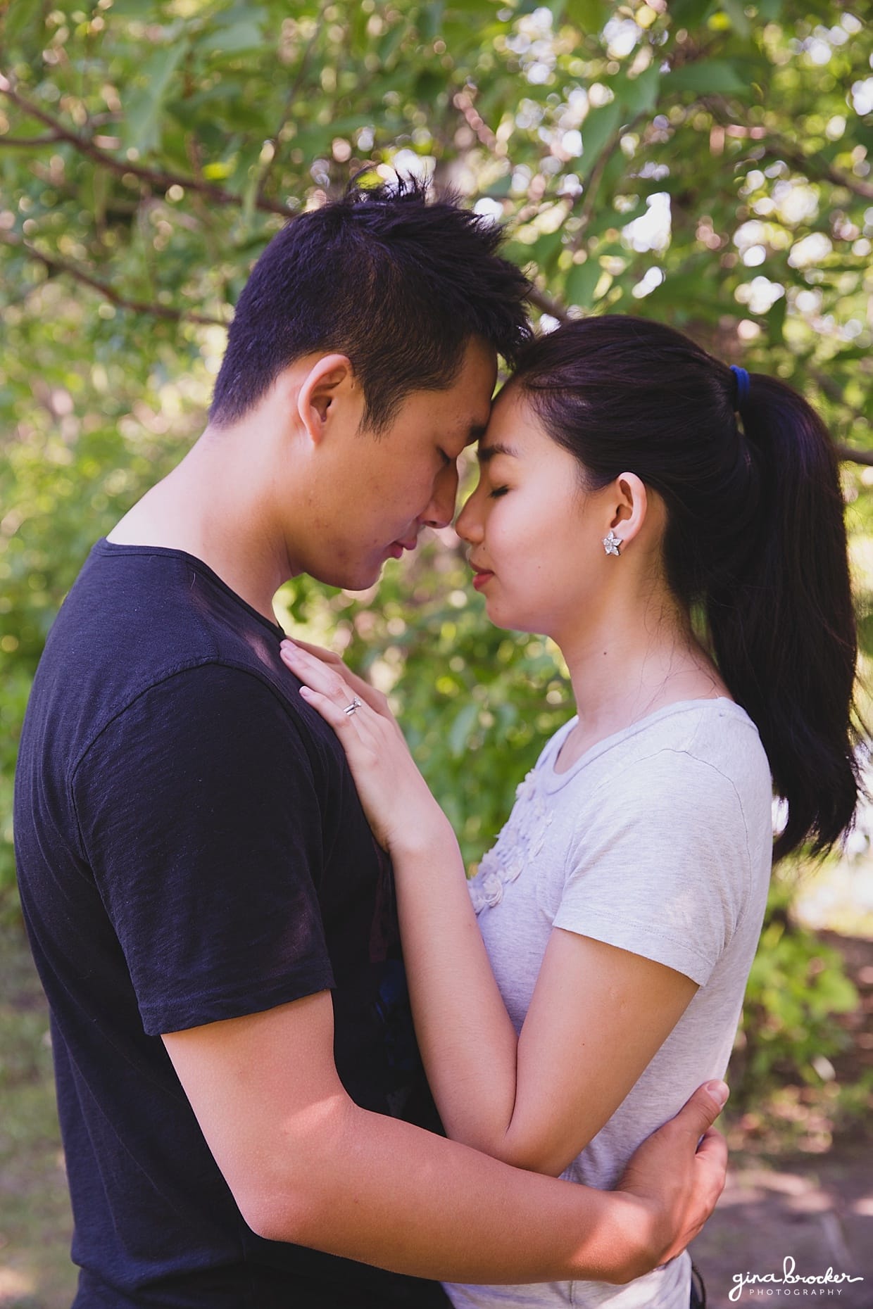 A couple hold each other and share a romantic moment during their park engagement in Boston's Back Bay Fens