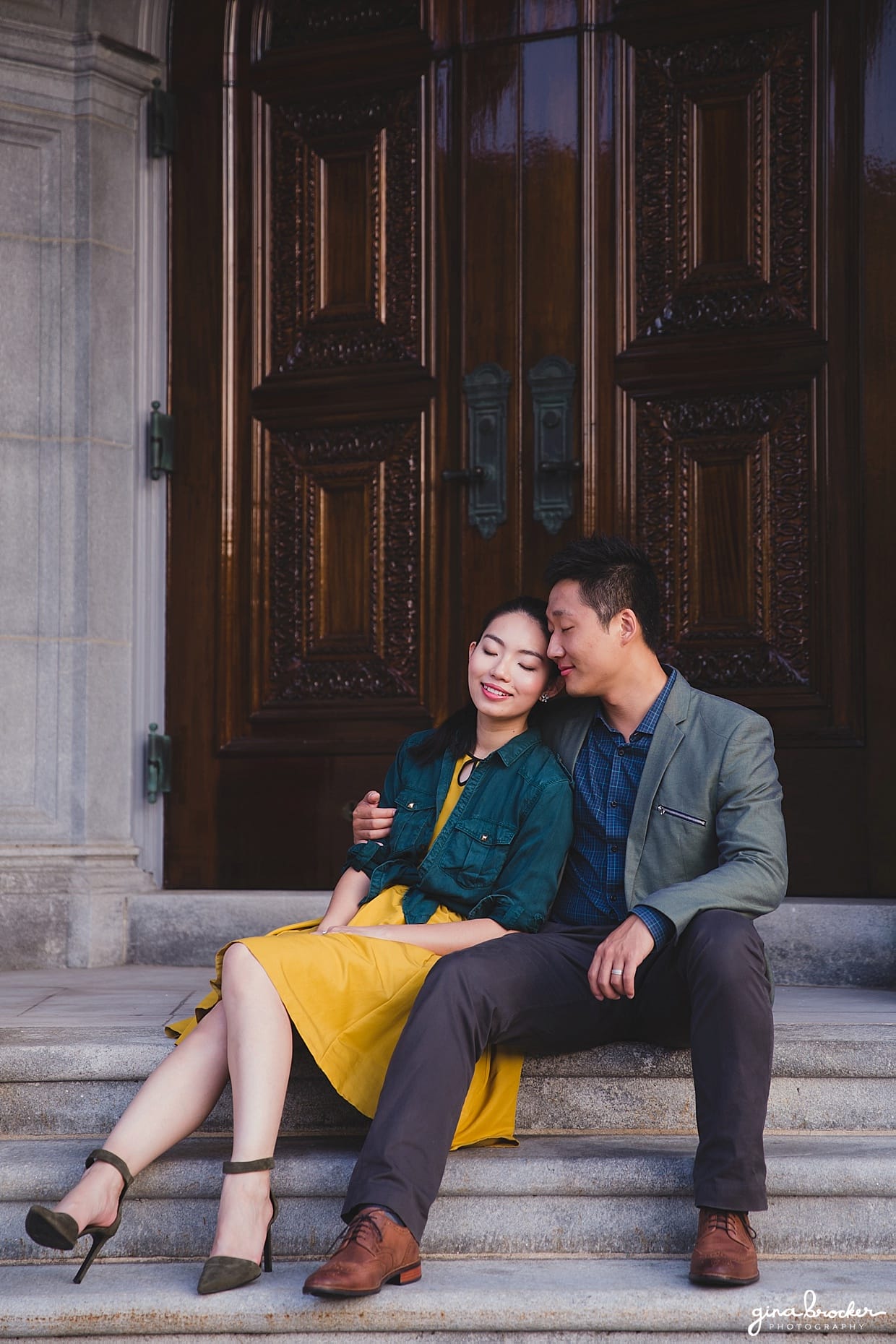 A couple sit on the steps of the Christian Science Center during their Boston engagement session
