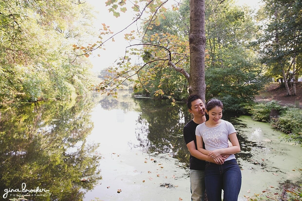 A beautiful photograph of a couple by the water during their park engagement session in Boston's Back Bay Fens
