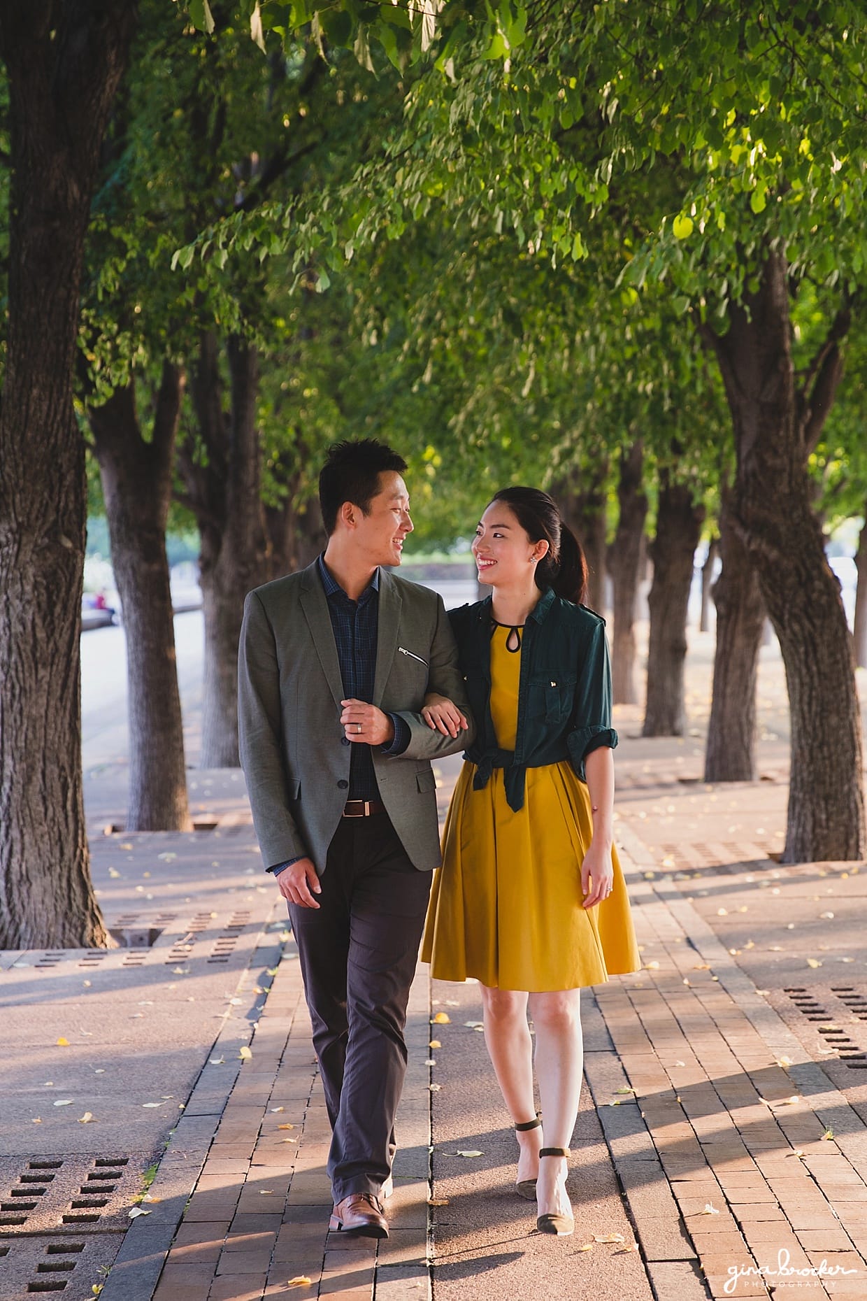 A couple walk arm and arm through a tree lined path during their Christian Science Center Engagement