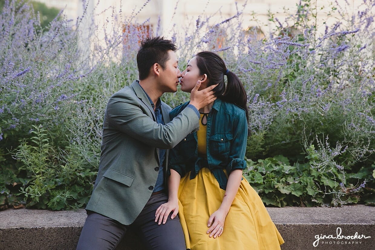 A couple share an intimate kiss in front of lavender plants during their Christian Science Center Engagement