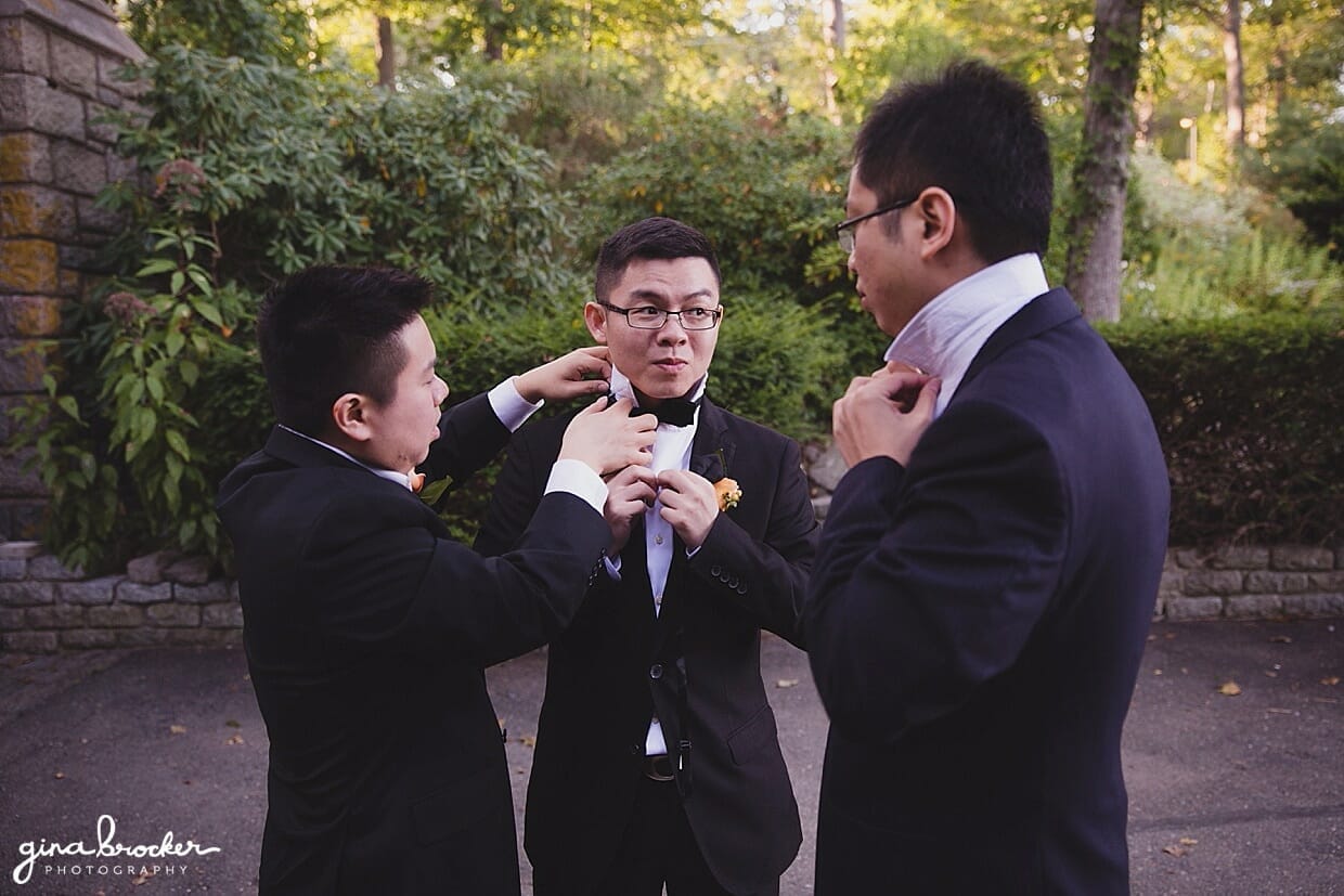 The groomsmen fix each other's ties and collars just before they get their photograph taken at Hammond Castle