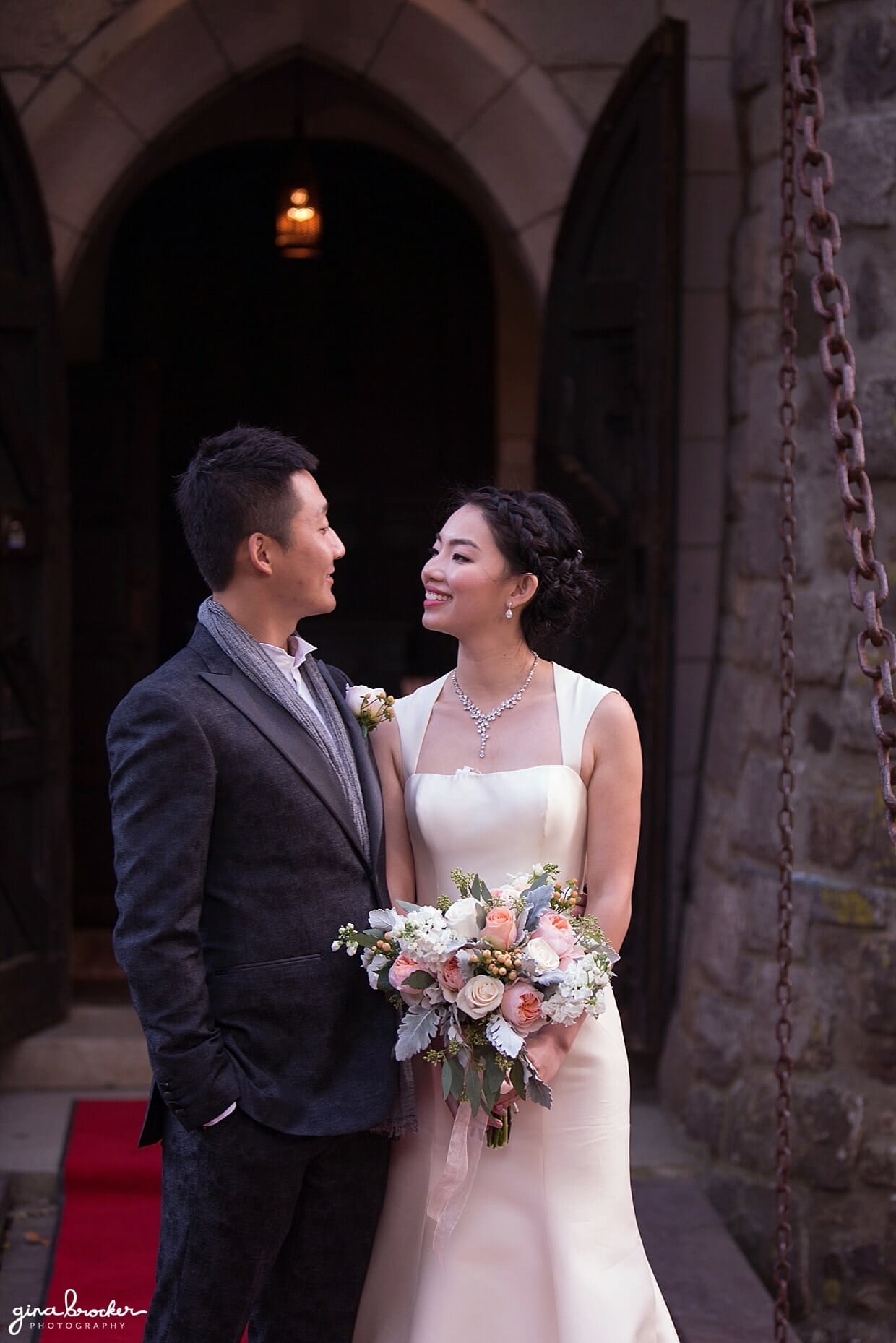 A portrait of a bride and groom outside the doors of Hammond Castle during their Gloucester wedding