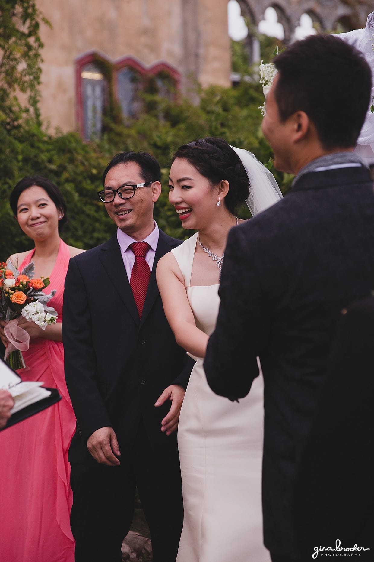 The bride smiles during her outdoor wedding ceremony in Hammond Castle