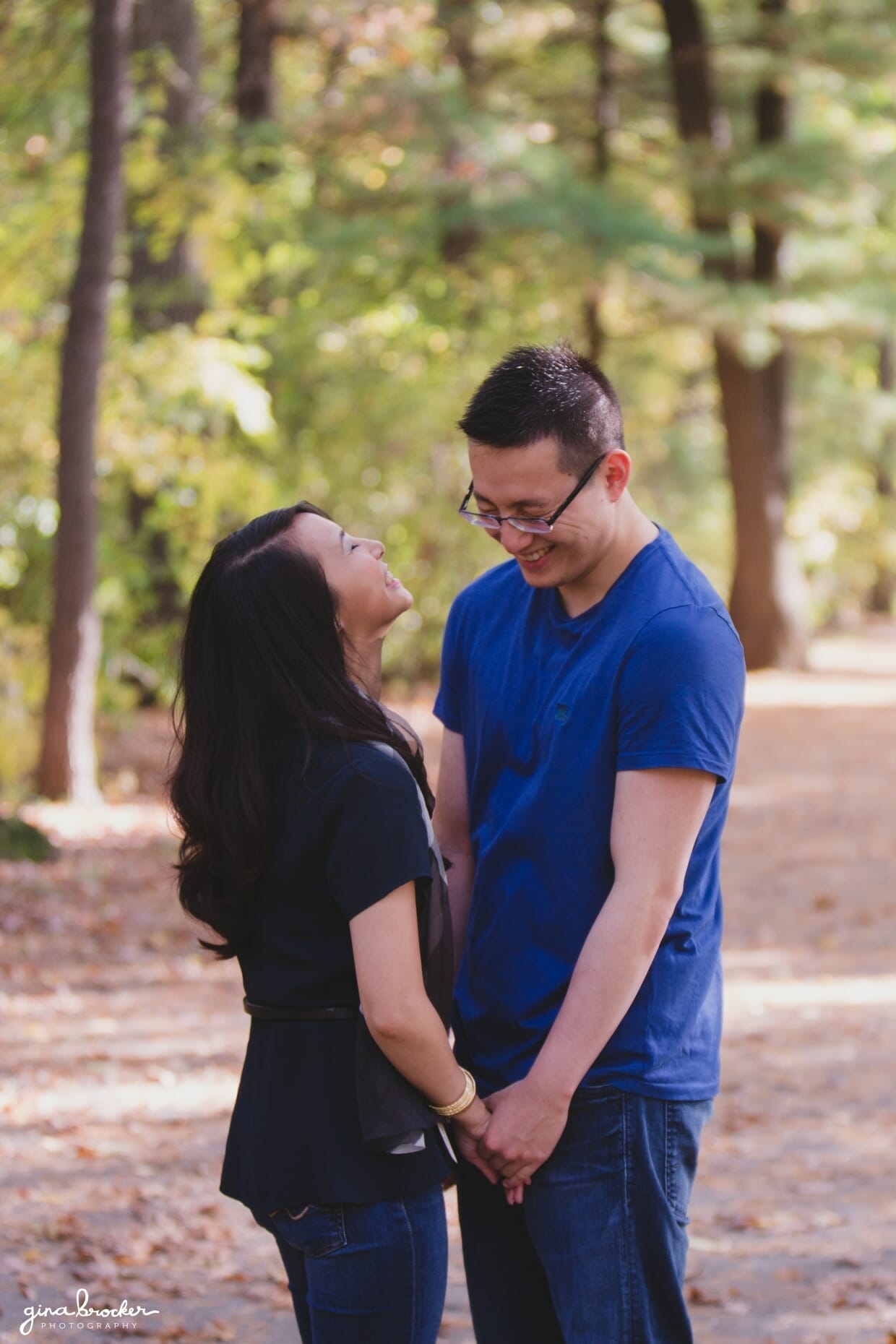 A couple laugh together in the woods during their boston fall engagement