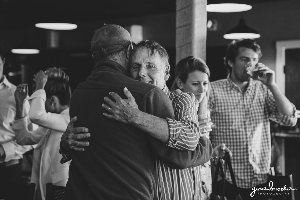 Guest hug when they meet at a wedding rehearsal dinner at the Back Yard BBQ restaurant in Nantucket, Massachusetts
