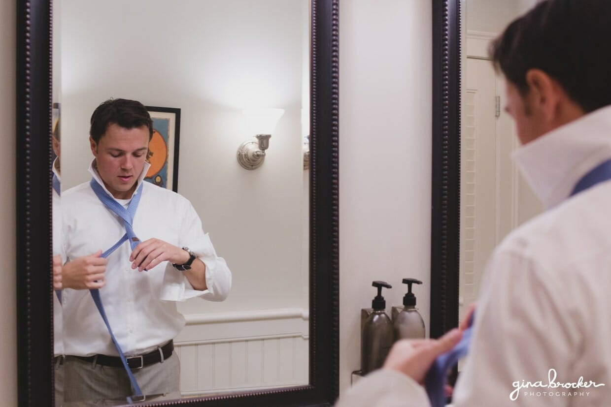 The groom puts on his tie on the morning of his Westmoor Club wedding in Nantucket, Massachusetts