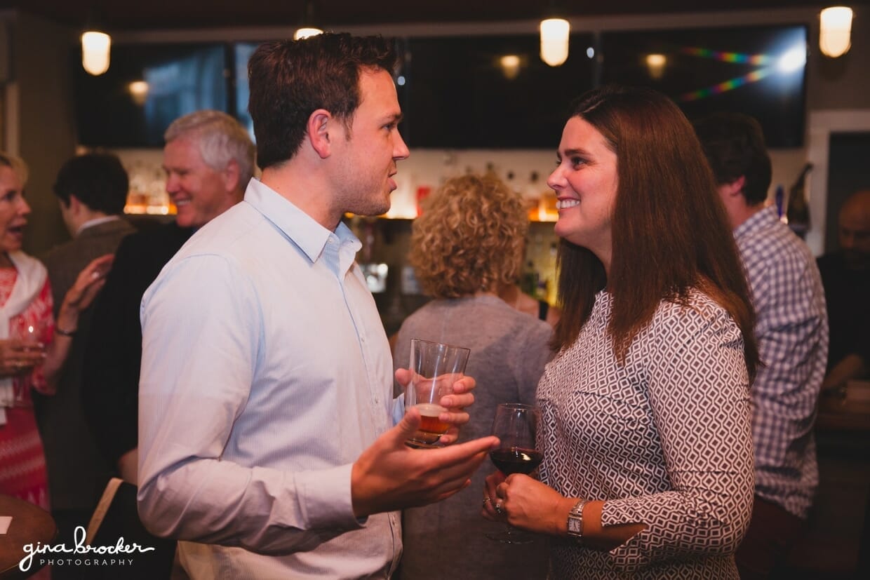 A natural photograph of two guests talking during a Nantucket rehearsal dinner at the Backyard BBQ restaurant in Massachusetts