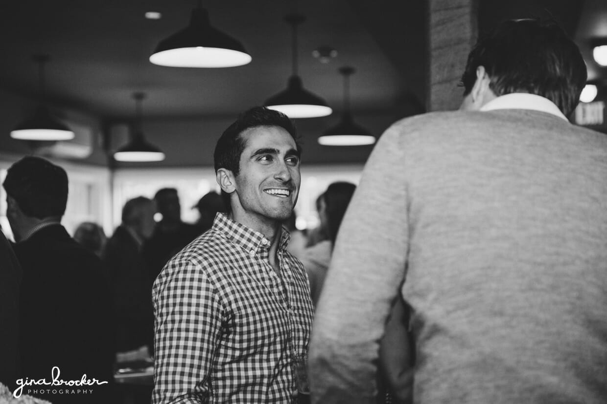 A candid photograph of guests talking during a rehearsal dinner in Nantucket