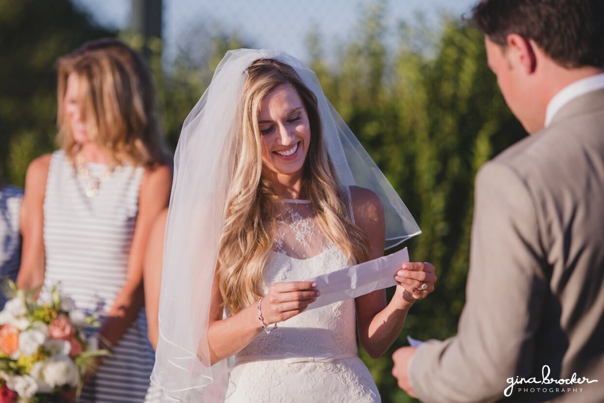 A bride reads her vows during her sunny outdoor wedding ceremony at the Westmoor Club in Nantucket, Massachusetts