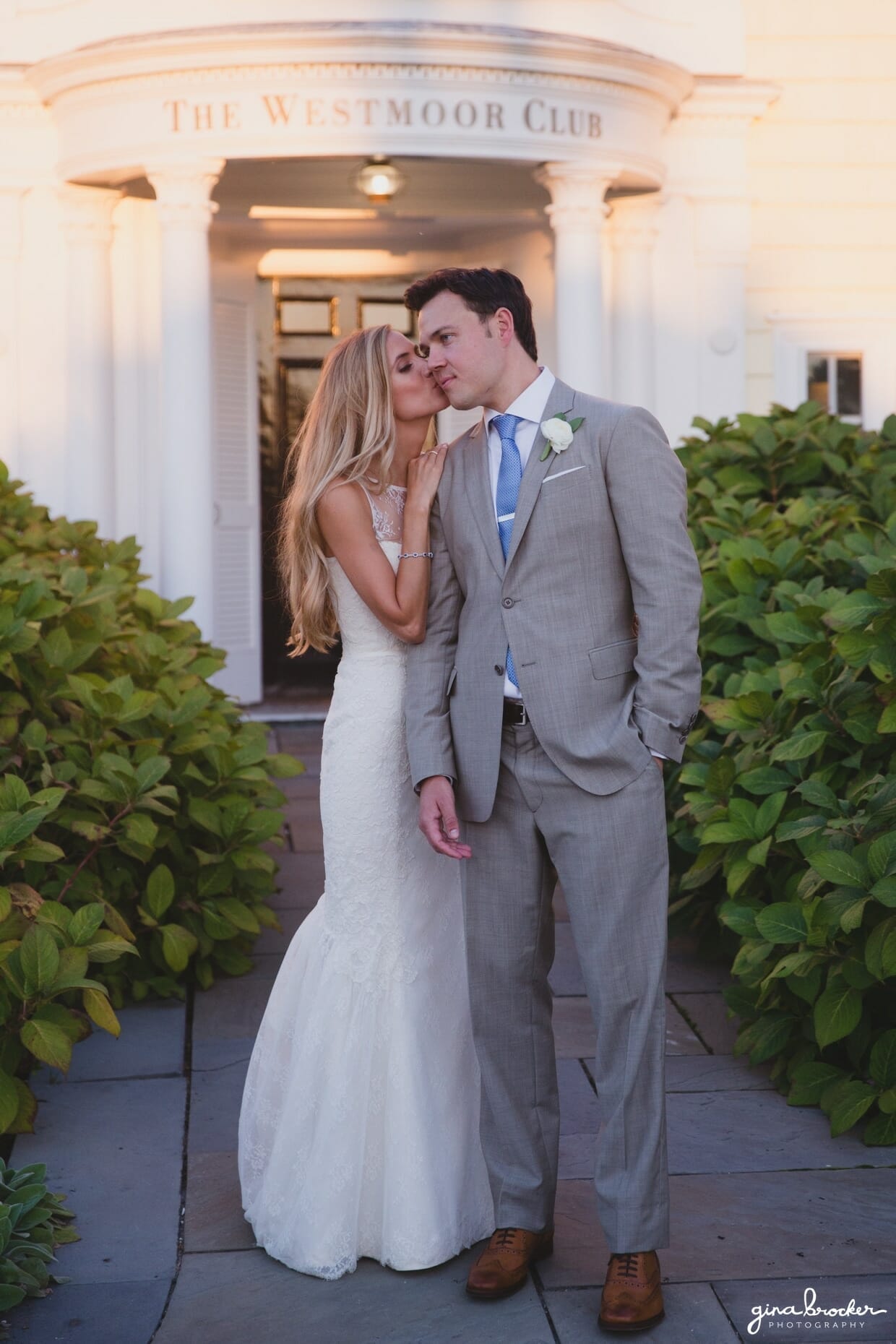 A sweet sunset portrait of a bride kissing her husband outside the Westmoor Club during their Nantucket Wedding