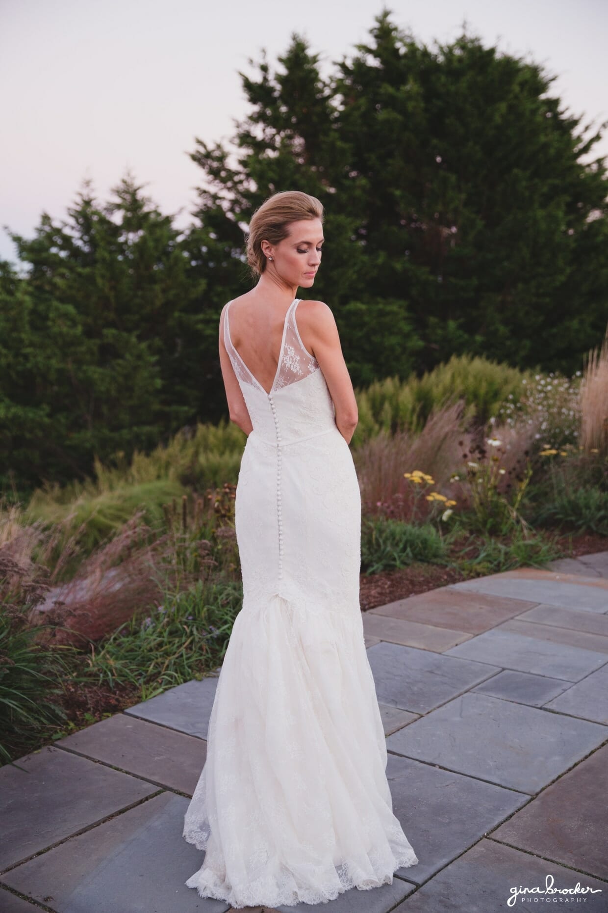 A sunset portrait of a bride featuring the back of her beautiful lace Amy Kuschel wedding dress during her Nantucket Wedding at the Westmoor Club