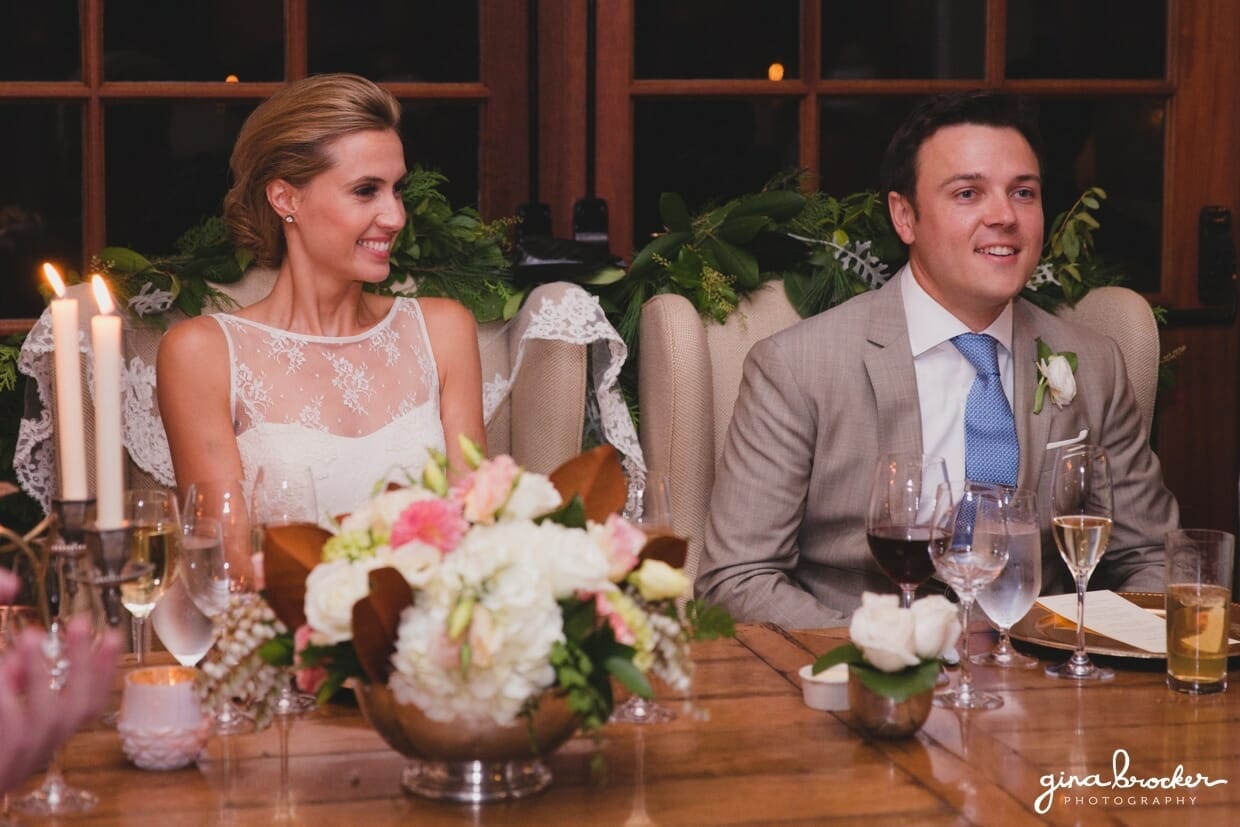 the bride and groom smile as they listen to the speeches and toasts during their Nantucket Wedding at the Westmoor Club
