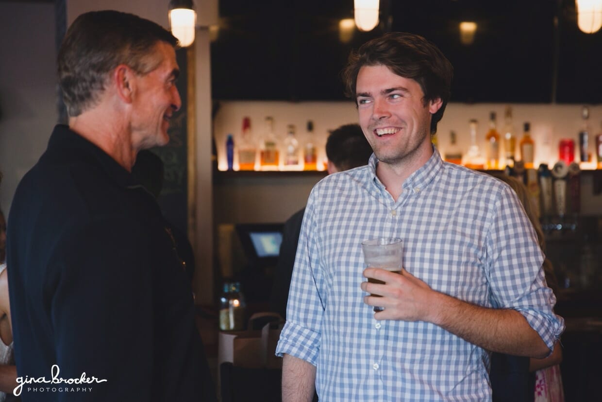 A candid photograph of guest talking and laughing during a Nantucket rehearsal dinner at Back Yard BBQ restaurant in Massachusetts