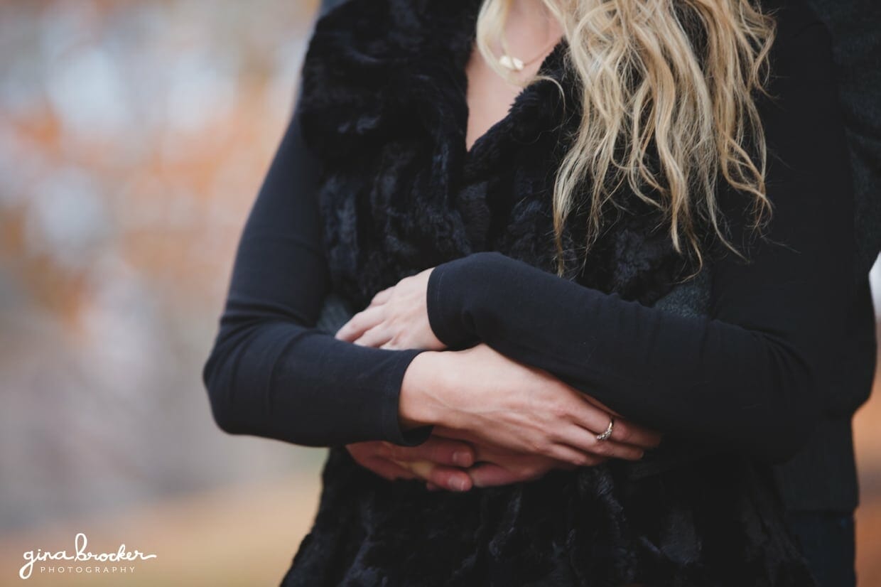 A detailed photograph of a couple cuddling during their fall couple session at the Arnold Arboretum in Boston, Massachusetts