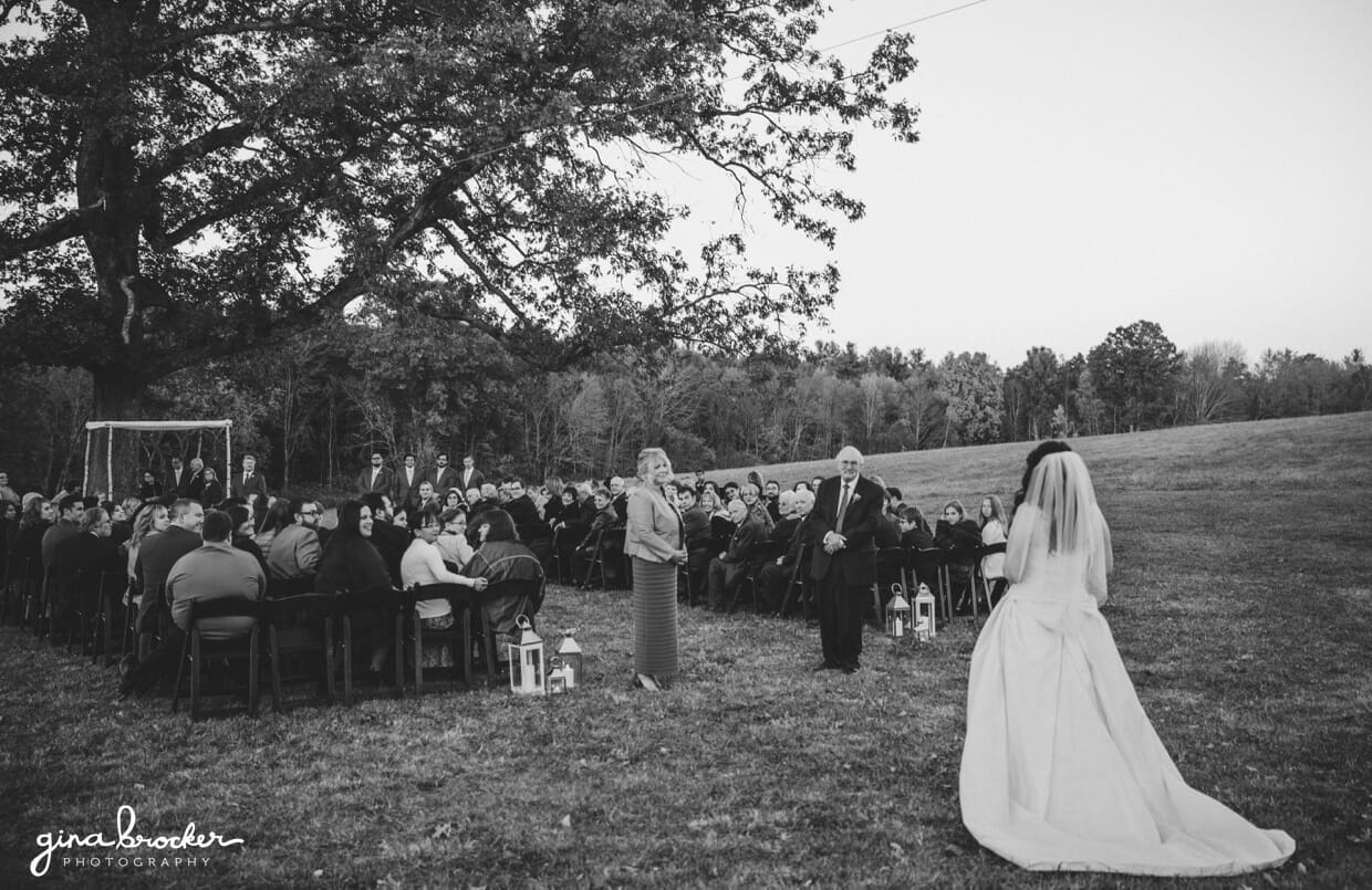 The bride walks up the aisle during her outdoor ceremony on a farm in Oxford, Massachusetts