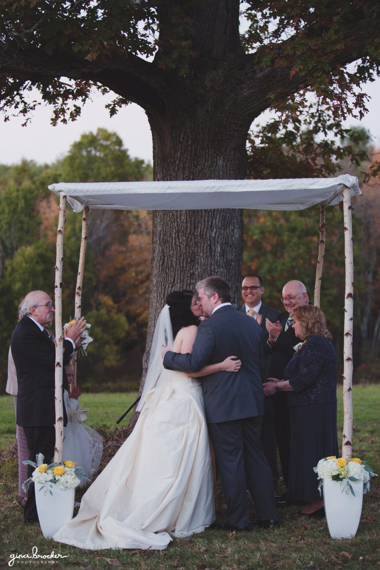 The bride and groom kiss after they are pronounced husband and wife during their Oxford farm wedding in Massachusetts