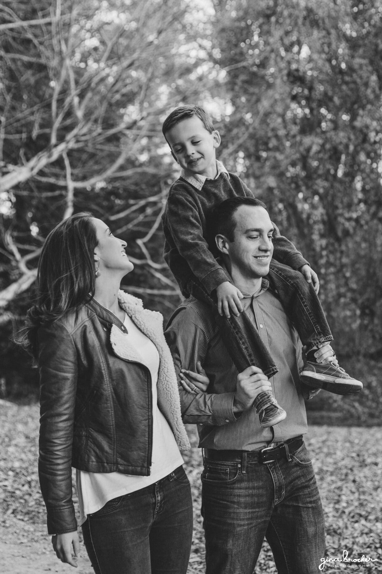 A cute and natural photograph of a family walking together in the park during their fall family photo session at the Arnold Arboretum in Boston, Massachusetts