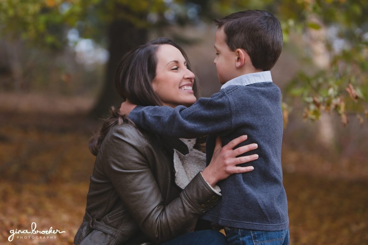 A sweet photograph of a mother and her son in the woods during their fall family photo session in Boston's Arnold Arboretum