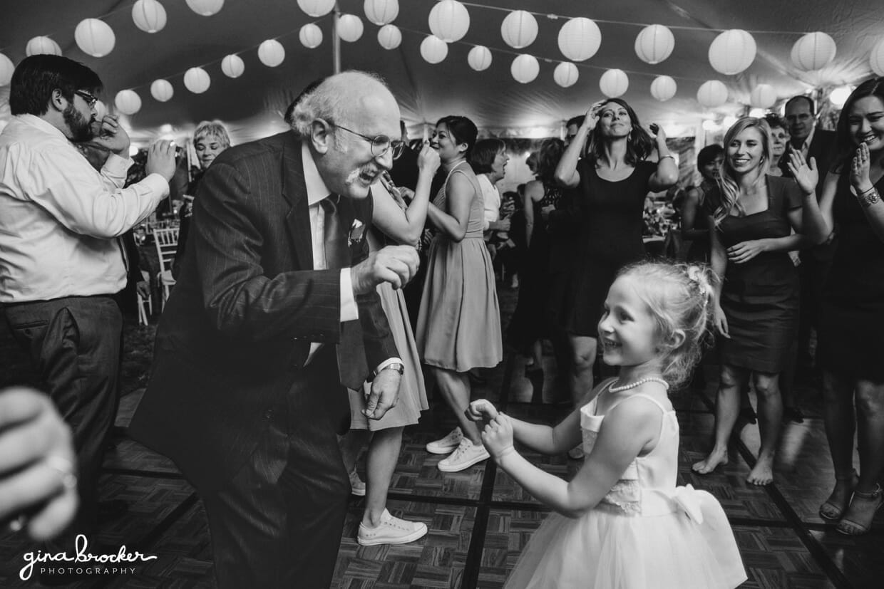 A flower girl dances with her grandpa during a farm wedding in Oxford, Massachusetts