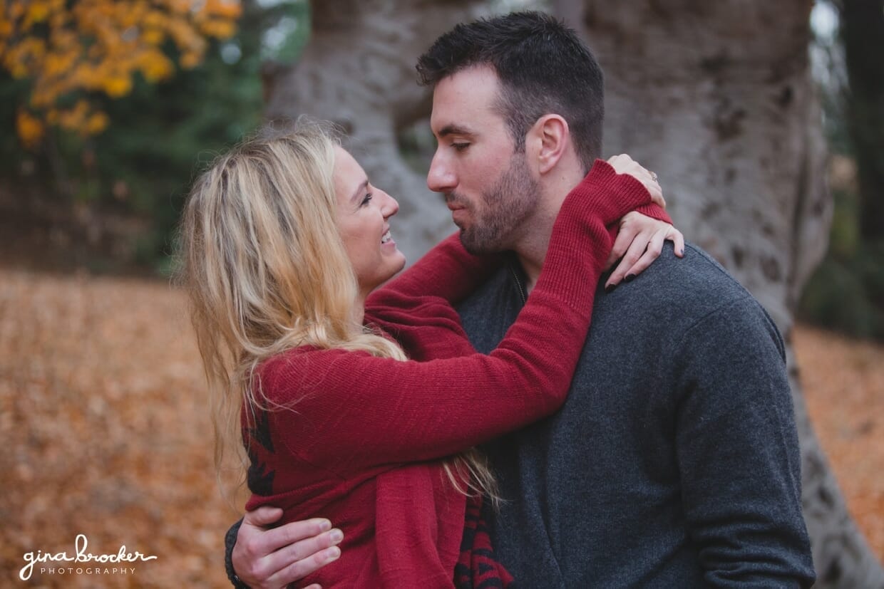 A sweet portrait of a couple laughing and hugging during their fall engagement session in the Arnold Arboretum in Boston, Massachusetts