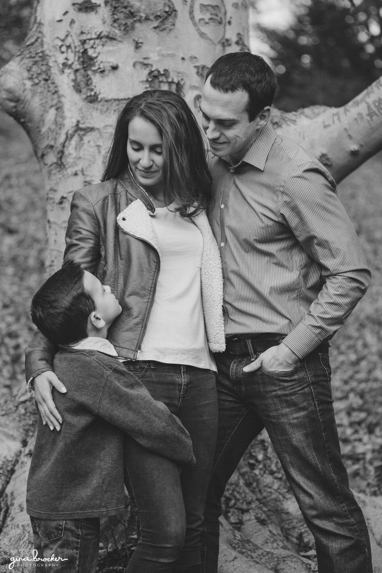 A portrait of a family beside a tree during their fall family photo session at the Arnold Arboretum in Boston, Massachusetts