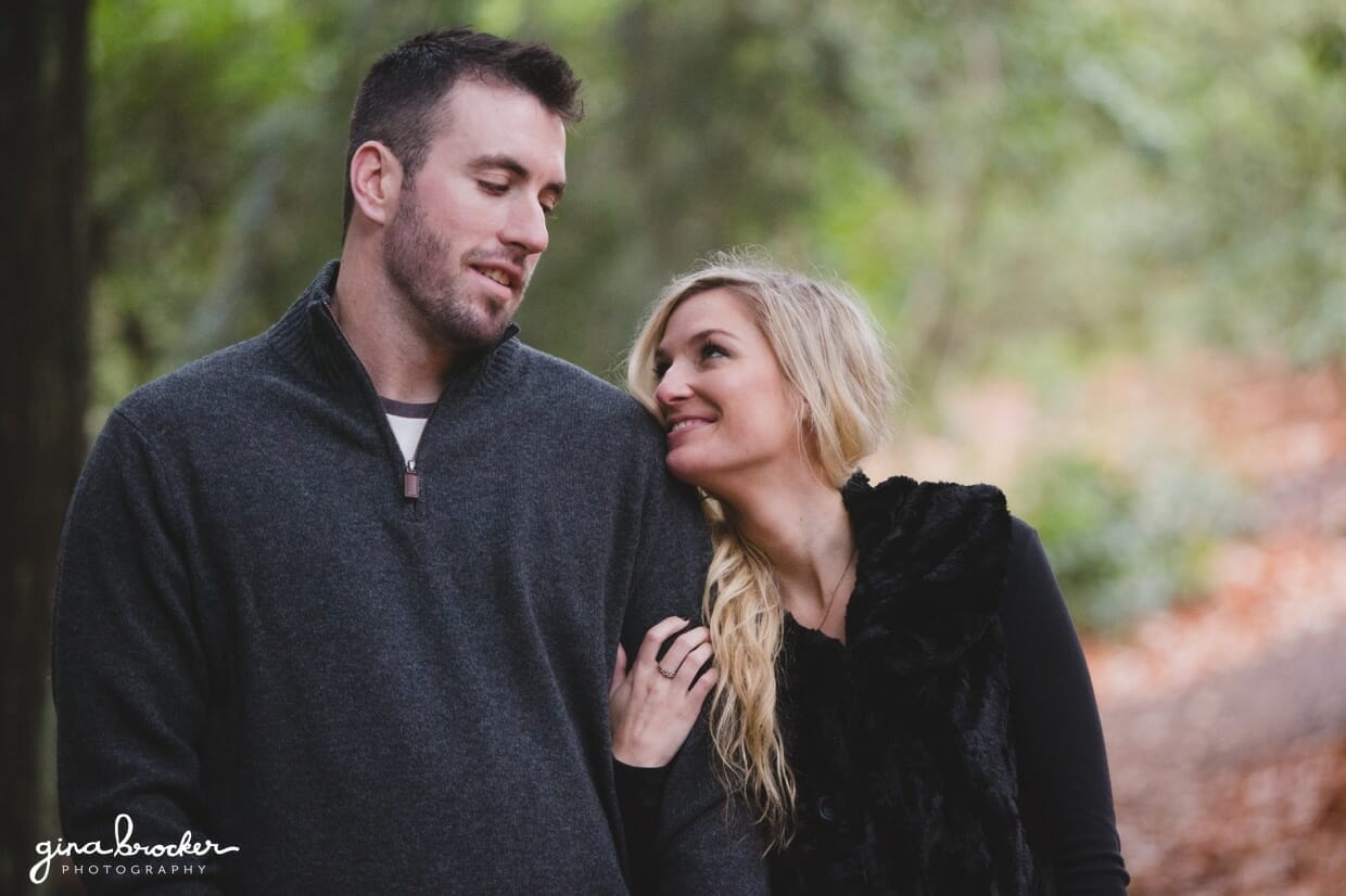 A sweet photograph of a couple smiling at each other during a woodsy couple session at the Arnold Arboretum in Boston, Massachusetts