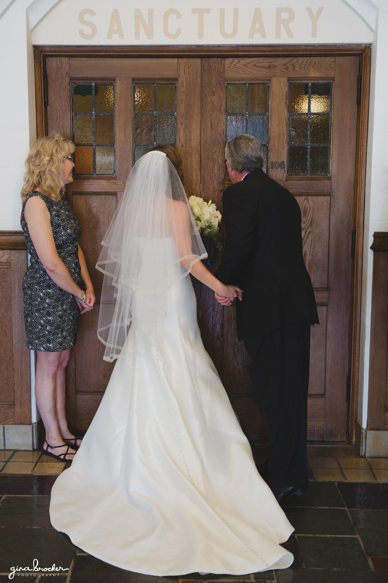A bride and her father look into the church ceremony moments before they walk up the aisle at a classic and elegant wedding in Boston