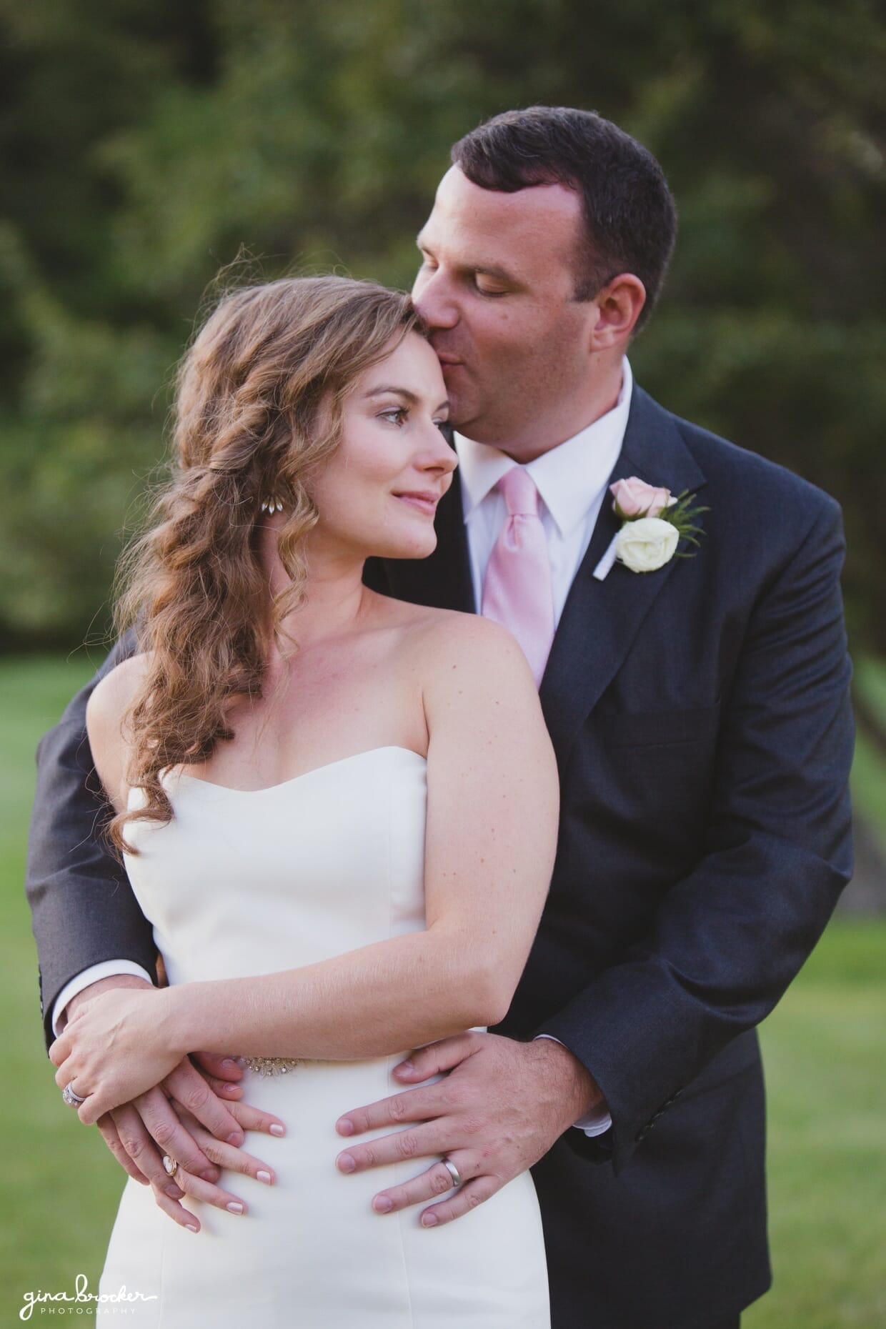 A romantic sunset portrait of a groom kissing his bride during their classic and elegant wedding in Boston, Massachusetts