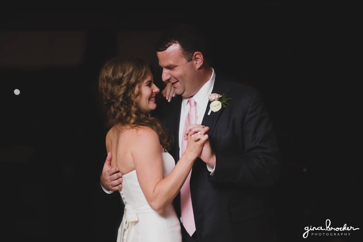 the bride and groom smile as they dance together during their classic and elegant wedding reception in Boston, Massachusetts