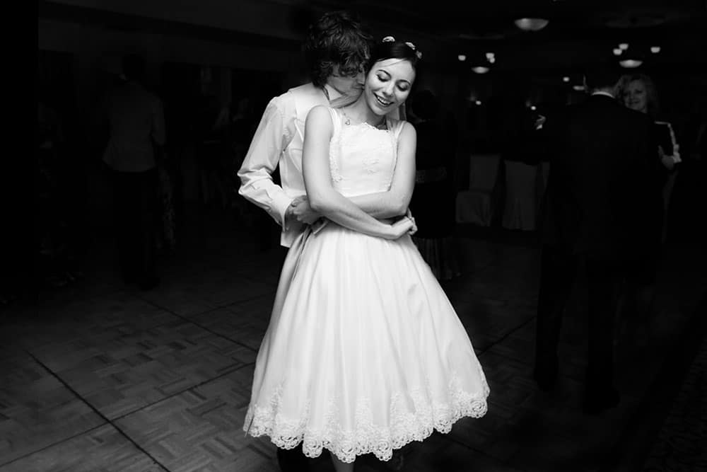 A documentary style photograph of a bride and groom dancing at their Boston Wedding