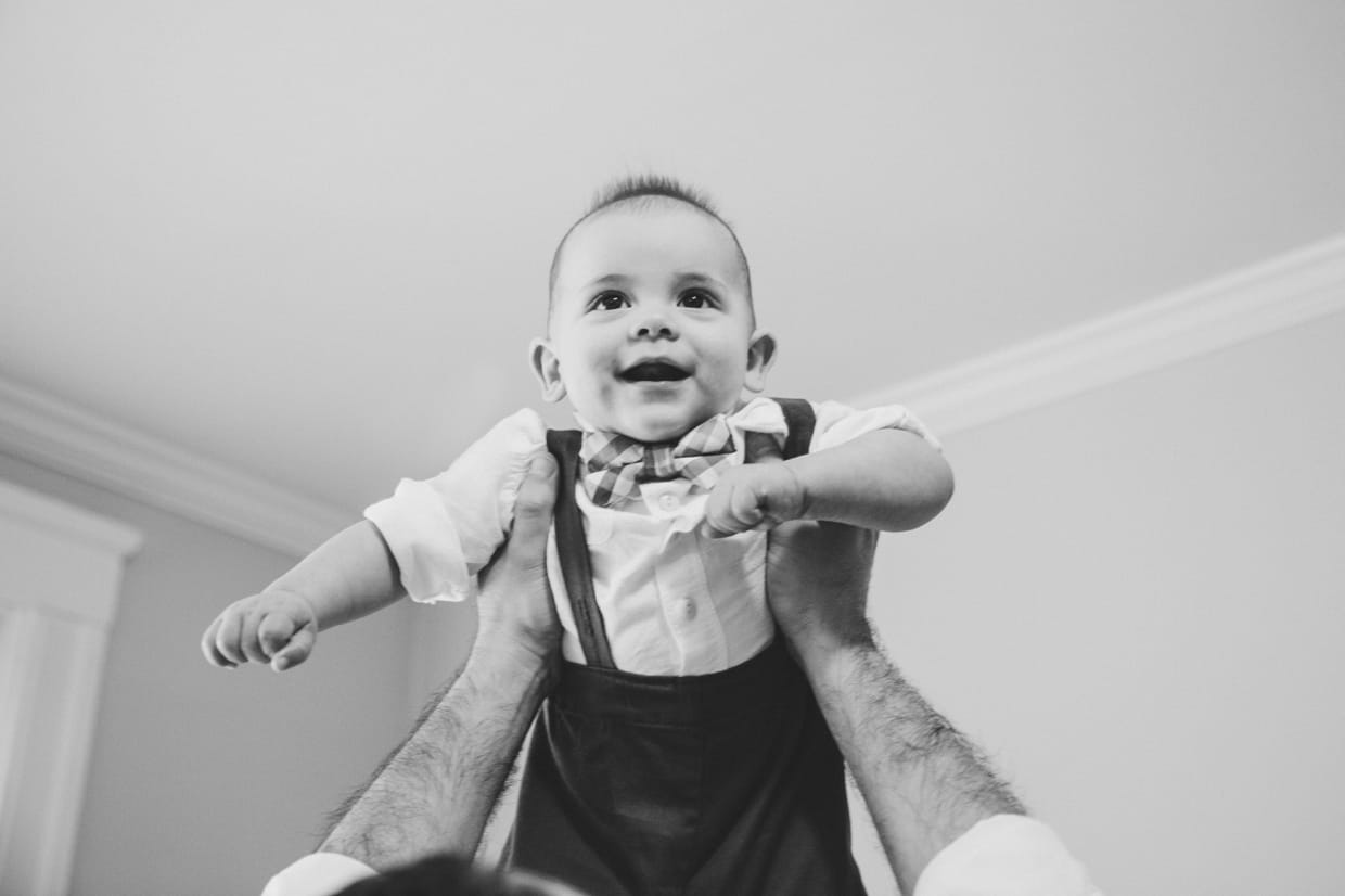 A beautiful candid photograph of a father playing with his baby boy during their in home family session in Boston.