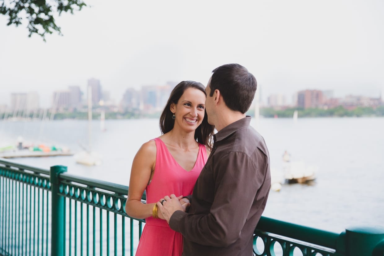 A sweet photograph of a couple smiling at eachother during their couple session on the Charles River in Boston.