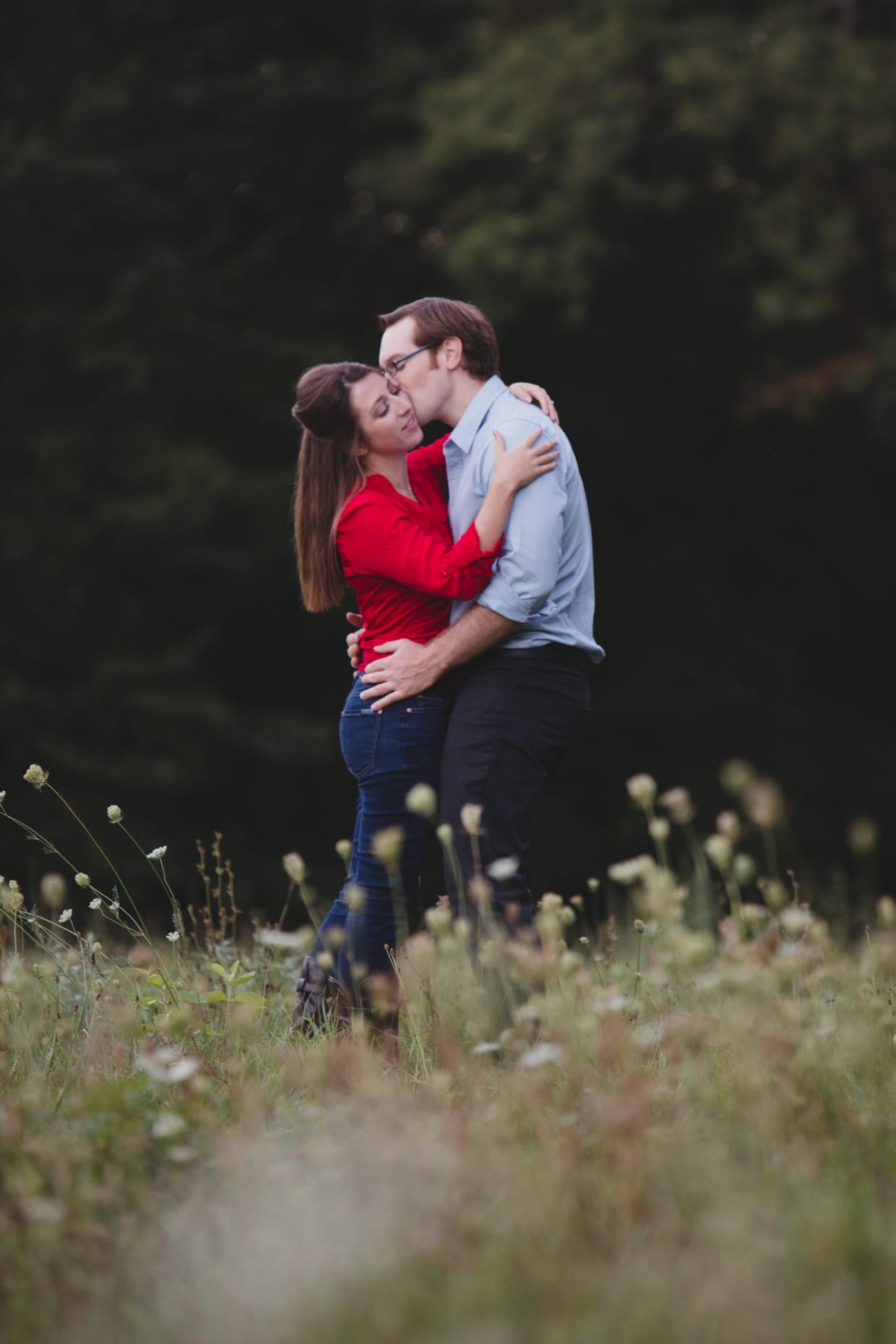 A sweet photograph of a couple kissing during their engagement session at the Boston's Arnold Arboretum