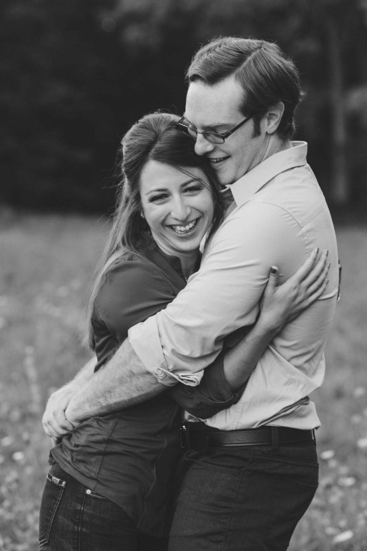A cute photograph of a couple laughing and hugging during their engagement session at the Arnold Arboretum in Boston, Massachusetts