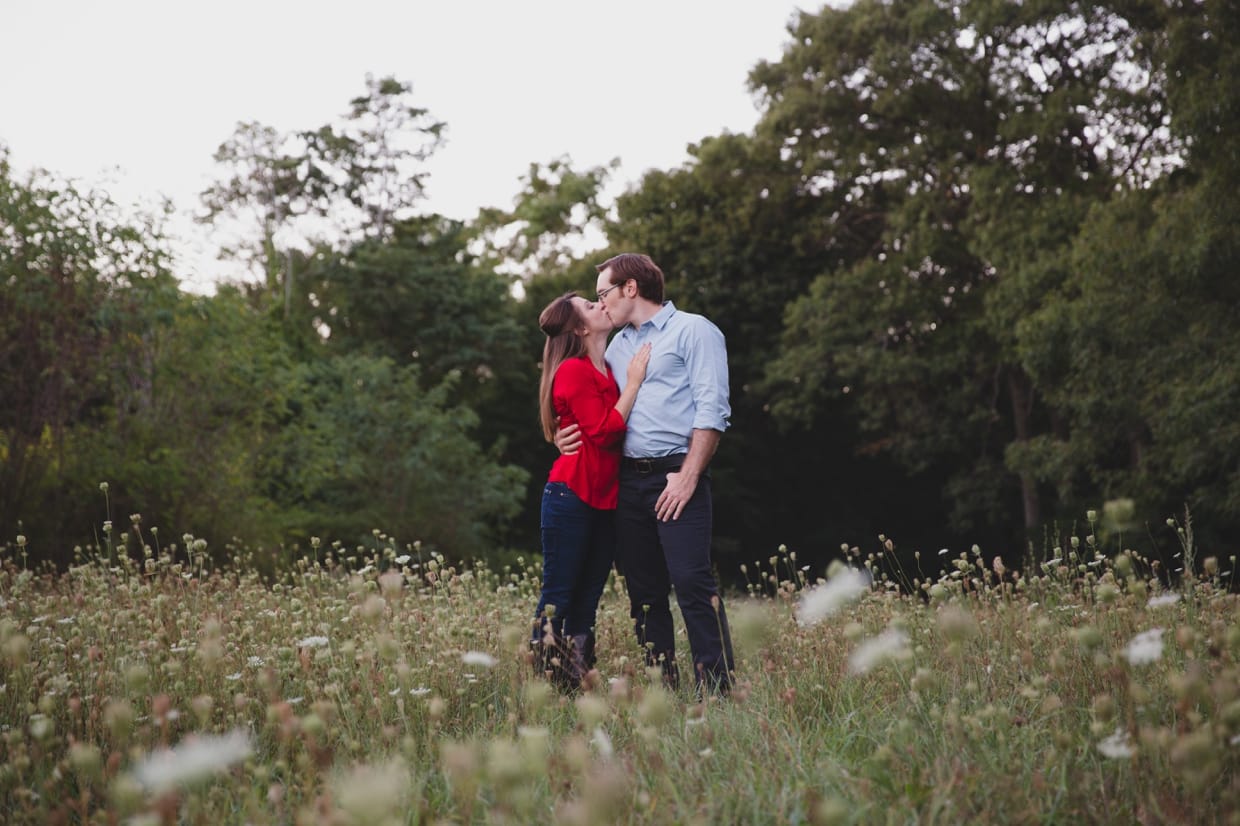 A beautiful photograph of a couple kissing in a field at the Arnold Arboretum during their Boston engagement session