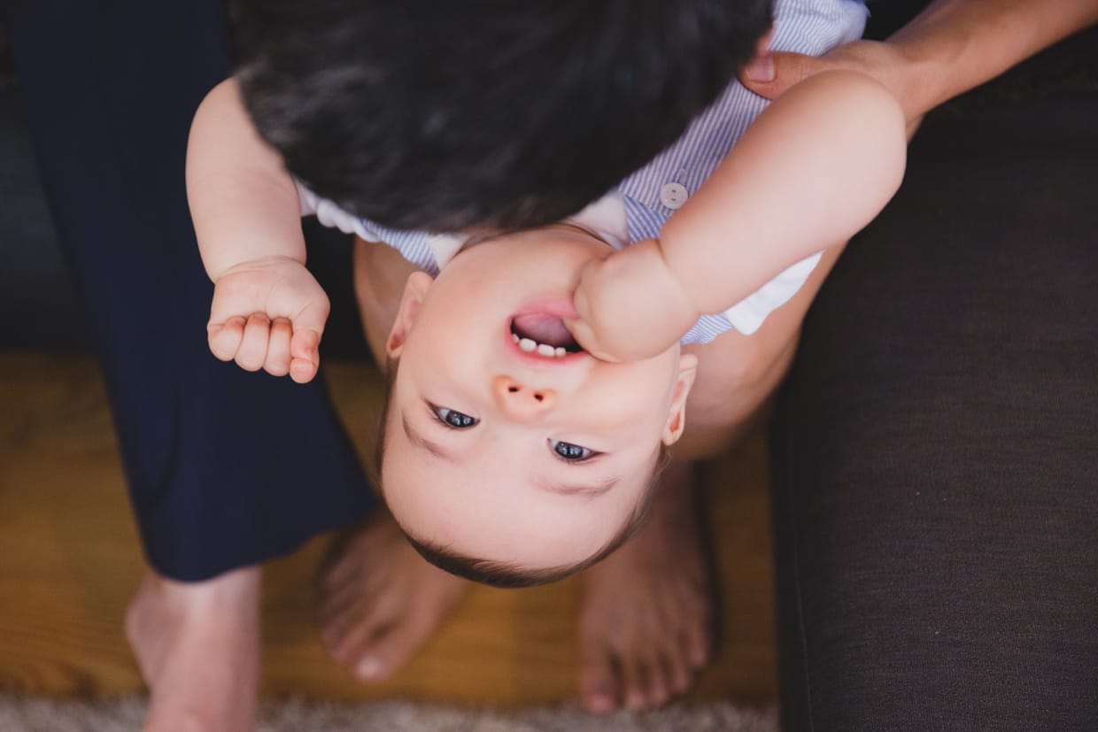 A cute and creative photograph of a mom playing with her baby boy during their Jamaica Plain family photo session at home