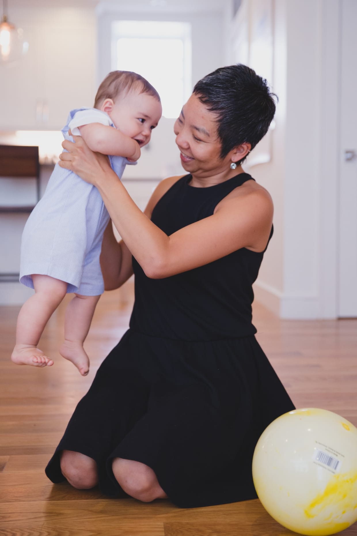 A sweet photograph of a mother playing with her son during their in home family photo session in Jamaica Plain