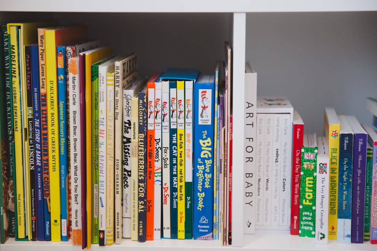 A detailed photograph of baby books on the shelf of a Jamaica Plain home during an in home family photo session