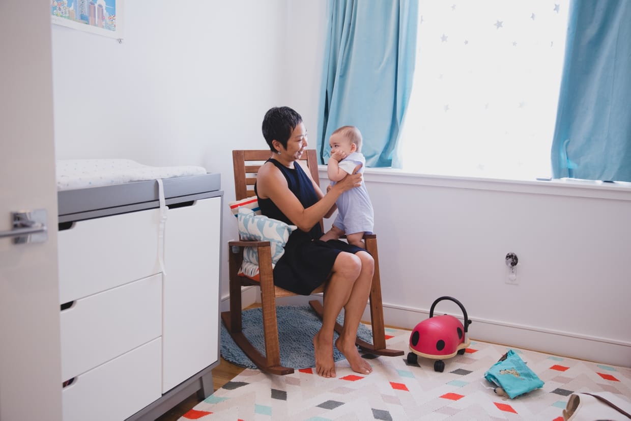 A documentary photograph of a mother holding her son during their in home family photo session in Jamaica Plain