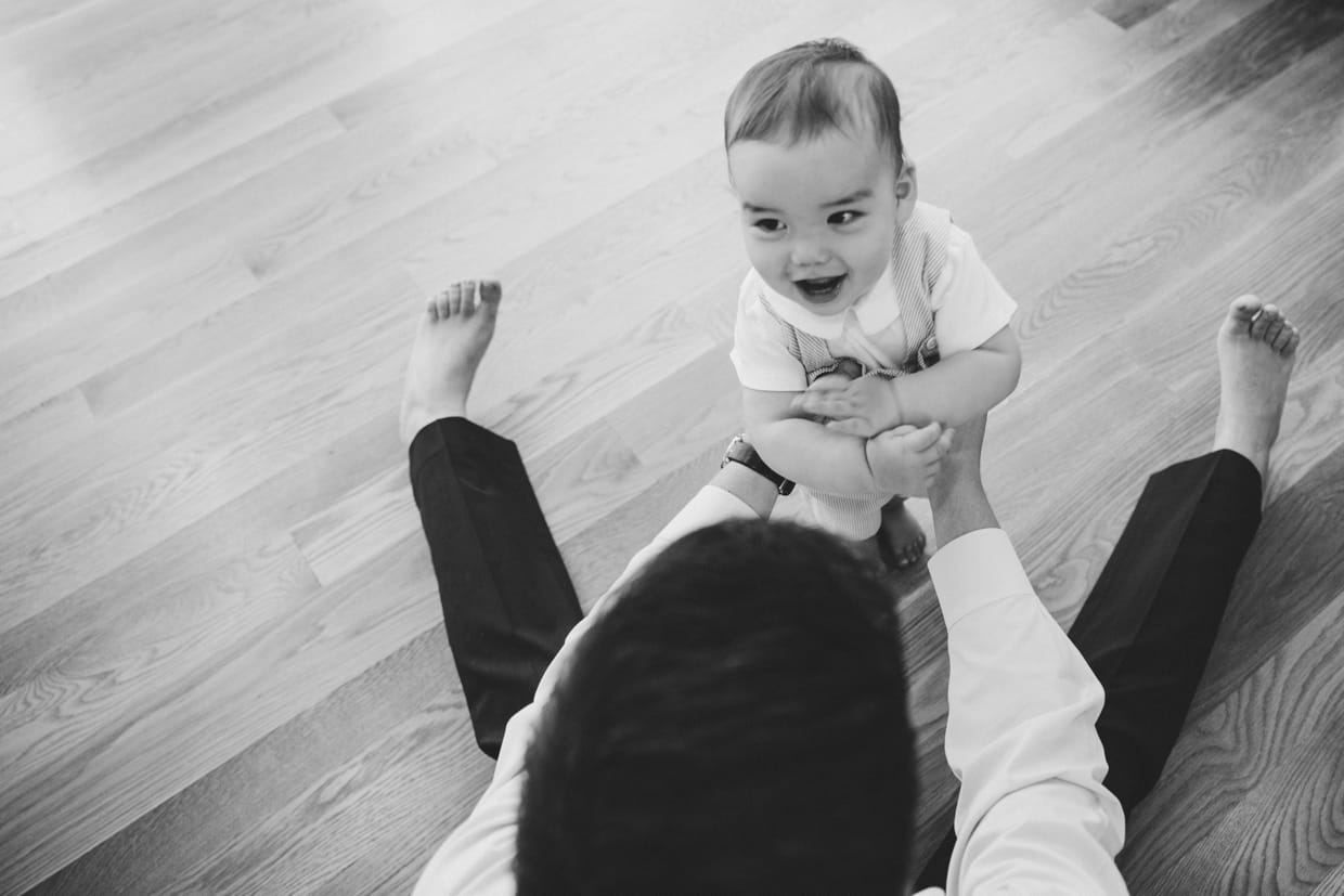 An amazing photograph of a father playing with his baby boy during their in home family photo session in Jamaica Plain