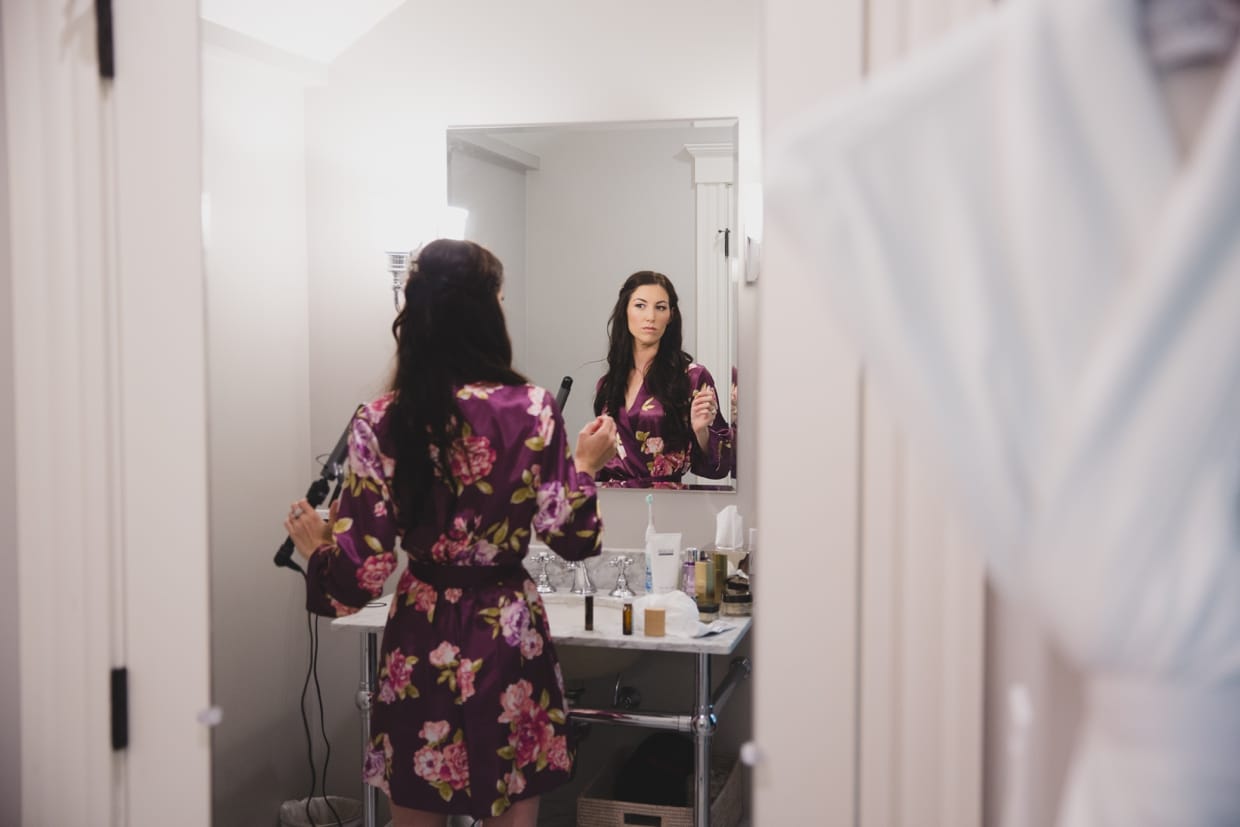 A bride curls her hair on the morning of her backyard wedding in Massachusetts