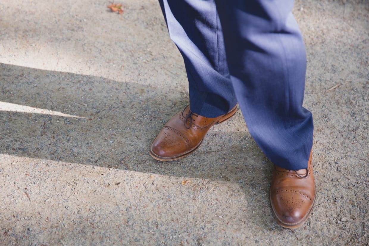 An artistic photograph of a groom's shoes before his backyard wedding in Massachusetts