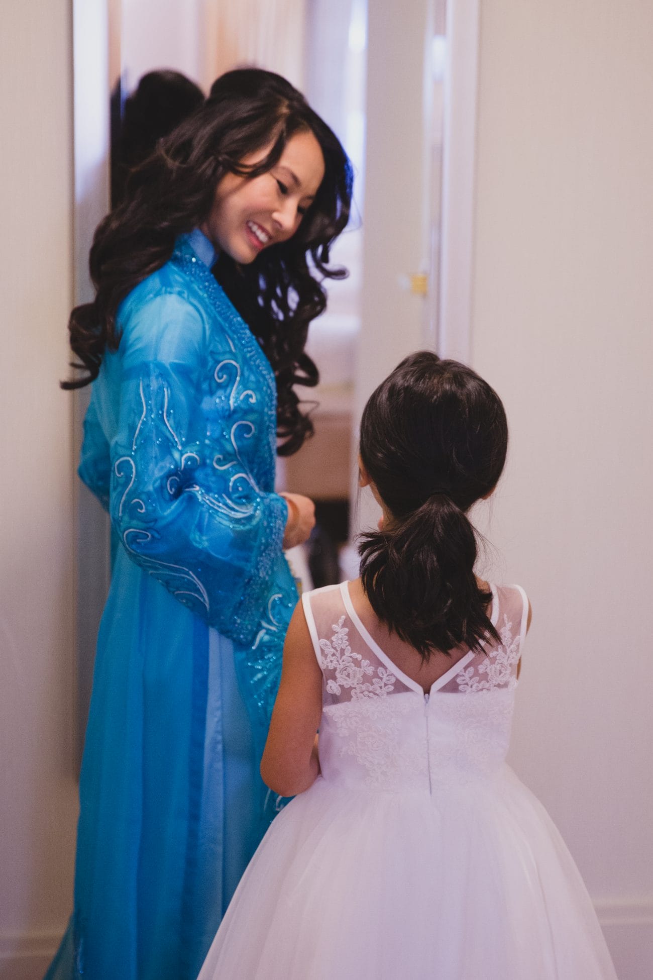 A bride laughs with the flower girl in the morning before her vietnamese tea ceremony in boston